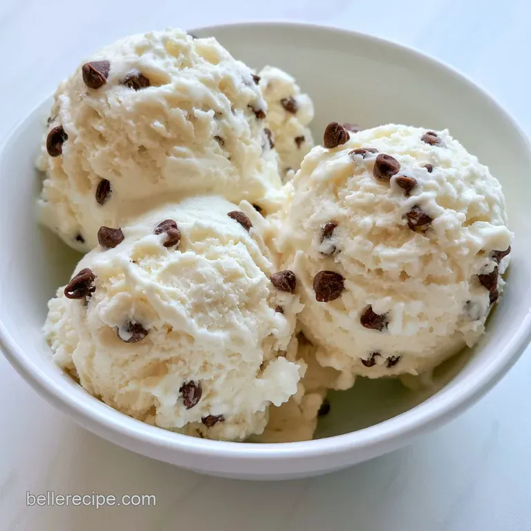 Chilled swirls of pale yogurt in a glass coupe, topped with golden cookie bits and a fresh mint leaf garnish.
