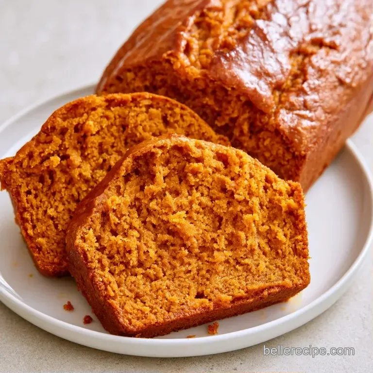 A thick slice of moist orange loaf on a matte white plate, topped with a swirl of cream and a dust of cinnamon.