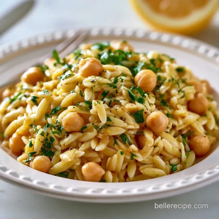 A colorful medley of pasta and chickpeas served in a ceramic bowl, garnished with a fresh lemon slice and herbs.