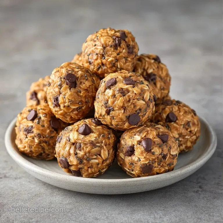 Small, round peanut-colored spheres stacked neatly on a slate board with a scatter of crushed roasted peanuts.