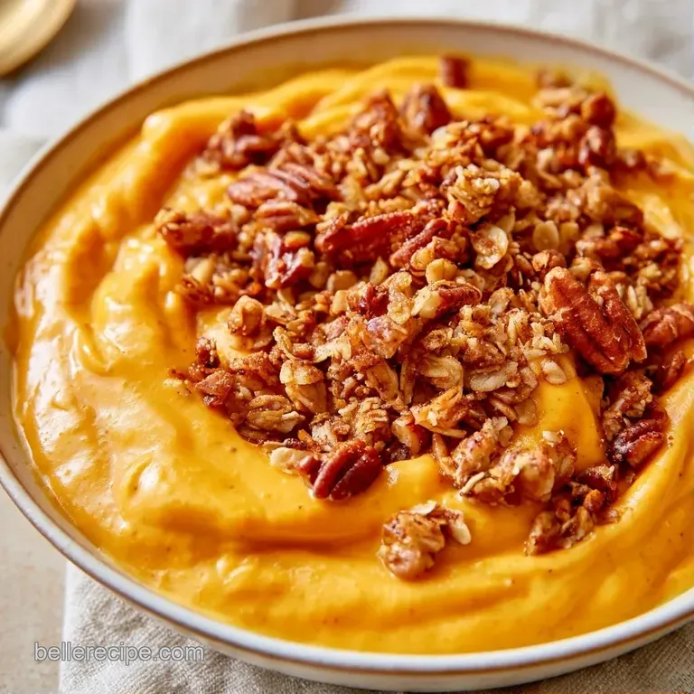 Vibrant orange creamy yogurt in a glass jar, topped with gold-brown granola and a sprinkle of cinnamon.