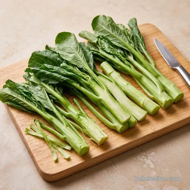 Peeled and halved Chinese broccoli stems on a cutting board.